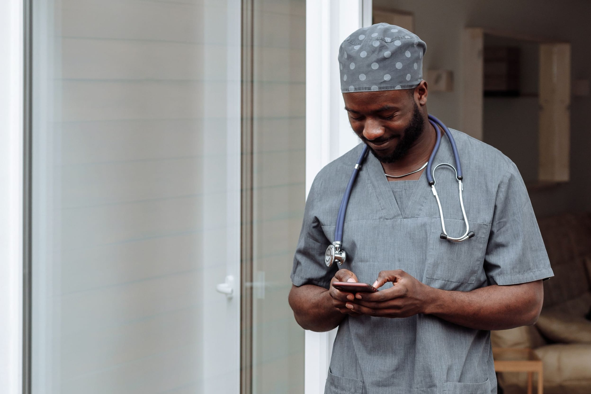 A caregiver arriving at a front door with a phone in hand at the start of a shift.