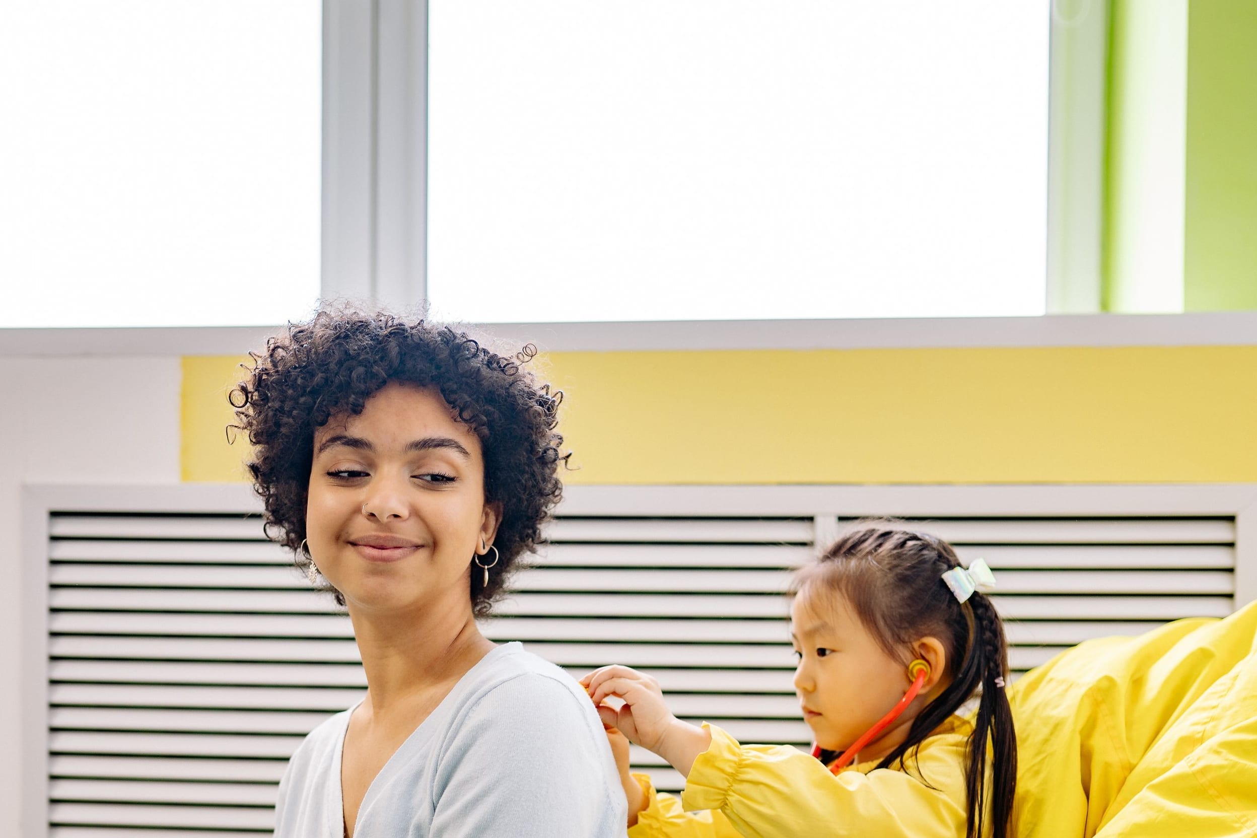 A care worker playing gently with a young child during a calm at-home visit.